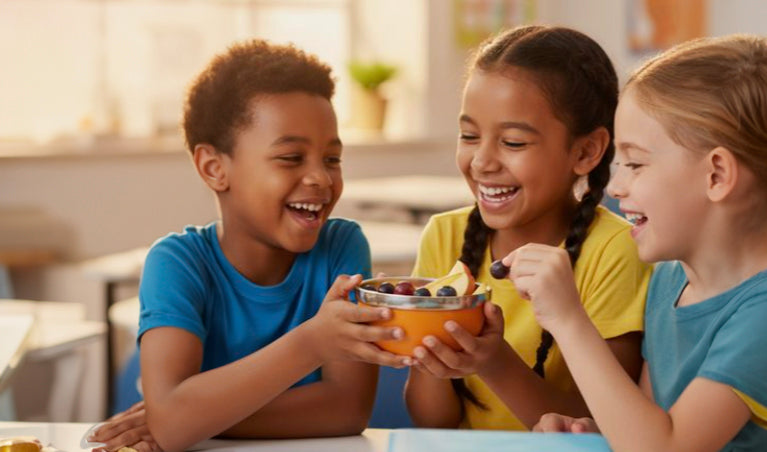 kid not eating school lunch - three kids sharing food and laughing at school